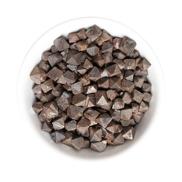 Magnetite crystals in a white bowl. Iron(II,III) oxide, octahedral, double pyramid and Platonic solid shaped. Most magnetic of all naturally occurring minerals. Can also be found in the human brain.