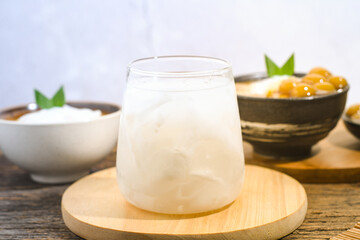 a glass of coconut water on a wooden table. Coconut water can prevent vomiting and treat dehydration. Ramadhan iftar drink