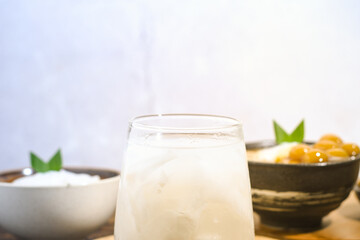 a glass of coconut water on a wooden table. Coconut water can prevent vomiting and treat dehydration. Not only that, coconut water also contains potassium, sodium, electrolytes, calcium and vitamin C
