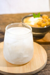 a glass of coconut water on a wooden table. Coconut water can prevent vomiting and treat dehydration. Ramadhan iftar drink