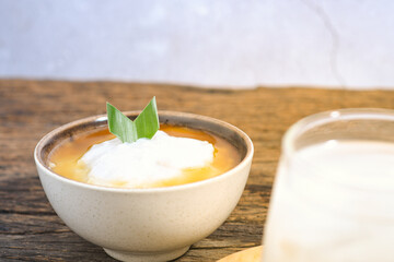 Bubur Sumsum served on wooden table, Javanese dessert porridge of rice flour, coconut milk with brown sugar syrup. A popular iftar food for breaking the fast Ramadan