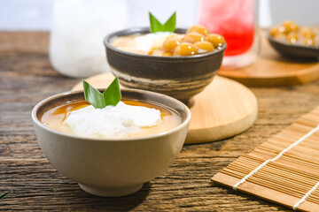 Bubur Sumsum served on wooden table, Javanese dessert porridge of rice flour, coconut milk with brown sugar syrup. A popular iftar food for breaking the fast Ramadan
