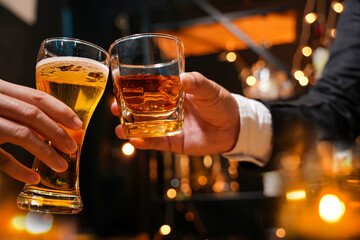 food and drink male friends are happy drinking beer and clinking glasses at a bar or pub.