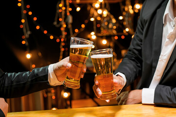 food and drink male friends are happy drinking beer and clinking glasses at a bar or pub.