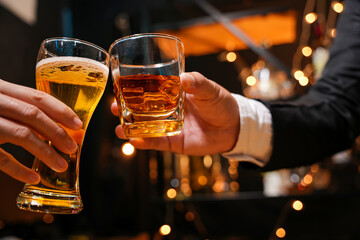 food and drink male friends are happy drinking beer and clinking glasses at a bar or pub.