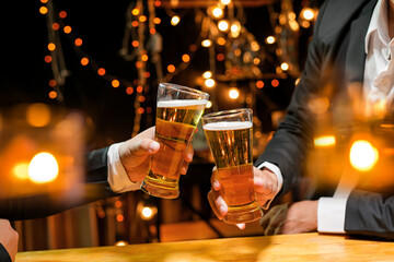 food and drink male friends are happy drinking beer and clinking glasses at a bar or pub.