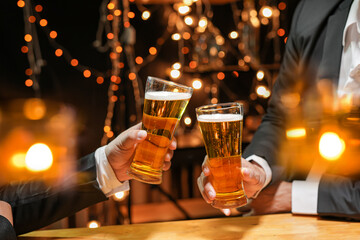 food and drink male friends are happy drinking beer and clinking glasses at a bar or pub.