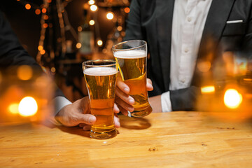 food and drink male friends are happy drinking beer and clinking glasses at a bar or pub.