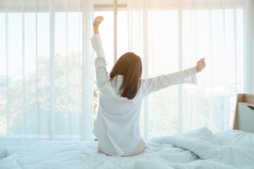 Young woman at home in morning, focus on alarm clock, alarm clock wake up woman in the room