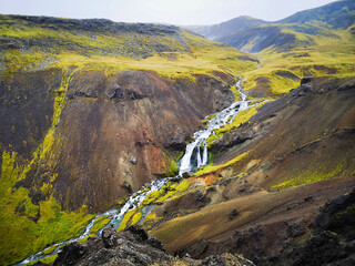 Iceland nature, view on a long waterfall and beautiful landscape