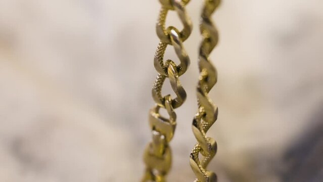 A gold chain handled in slow motion.