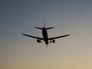 Silueta avión aterrizando atardecer