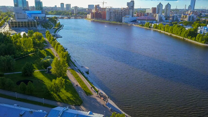 Fototapeta na wymiar Russia, Ekaterinburg - June 7, 2018: Embankment of the central pond. Flight to skyscrapers and new buildings, From Dron