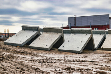 Large reinforced concrete structures at the construction site. Preparation for the installation of reinforced concrete products. Construction work on the construction of foundations.