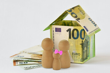 House made of euro banknotes and wooden pawn on white background - Concept of family, home and financial protection