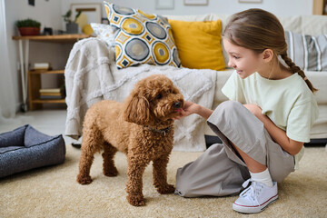 Little girl talking to her dog during her leisure time at home