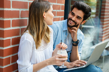 Happy couple in love using digital devises for work, study or social media.