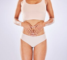 Heart, body and hands on woman stomach in studio as motivation for weight loss, diet or fitness. Female on a white background with hand emoji for gut health, wellness and skin care in underwear