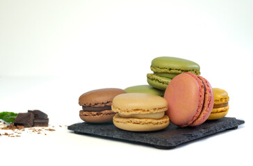 colorful macarons on white background with chocolate and mint