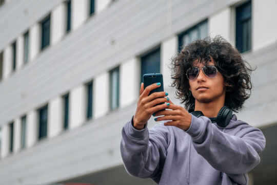 young afro hair man with phone in the street making a selfie or live video