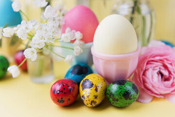 Obraz na płótnie Canvas Easter eggs, flowers on yellow background