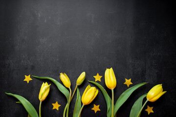 bouquet of yellow tulips coffetti stars in gold color on a black background. top view. copy space
