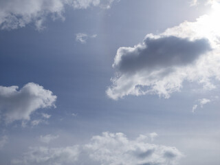 Cloudy sky for background. Clouds illuminated by the sun in a light blue sky