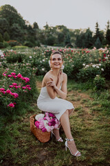 young woman with basket with pink peonies 