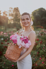 young woman with basket with pink peonies 