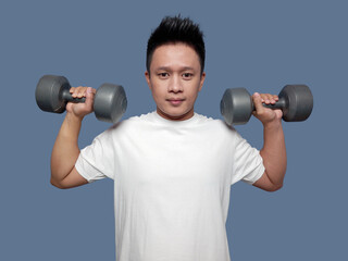 Fototapeta na wymiar Young man doing the movement of lifting or biceps curl with dumbbells in both hands