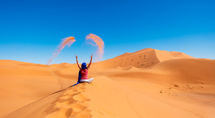 Fototapeta na wymiar Woman in the desert threw sand- Morocco