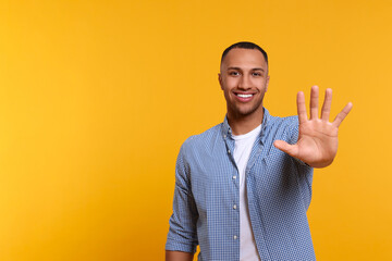 Man giving high five on yellow background. Space for text