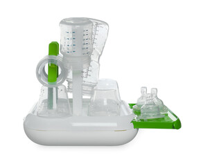 Dryer with baby bottles and nipples after sterilization on light grey table against white background