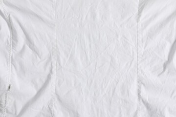 Naklejka na ściany i meble Crumpled white fabric as background, top view