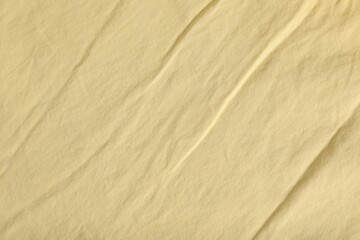 Crumpled pale yellow fabric as background, top view