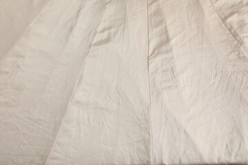 Fototapeta na wymiar Crumpled beige fabric as background, closeup view