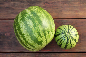 Different delicious ripe watermelons on wooden table, top view