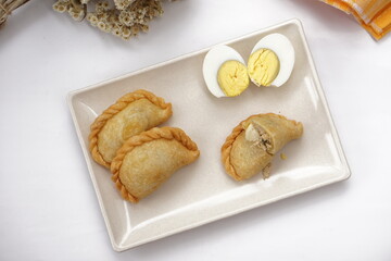 Indonesian snack called pastel. It filled with meat, vegetables, egg, and rice vermicelli. Deep fried in vegetable oil. Commonly sold in traditional market. 