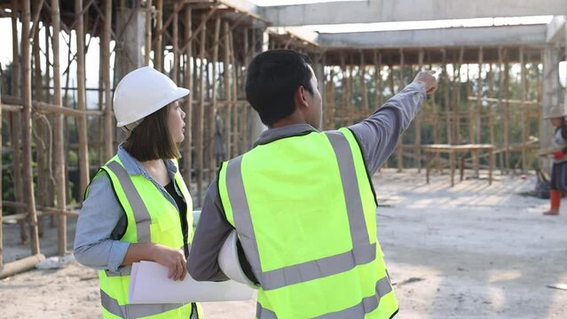 Construction engineers discussing project at construction site, Building construction collaboration concept, Video 4k slow motion.