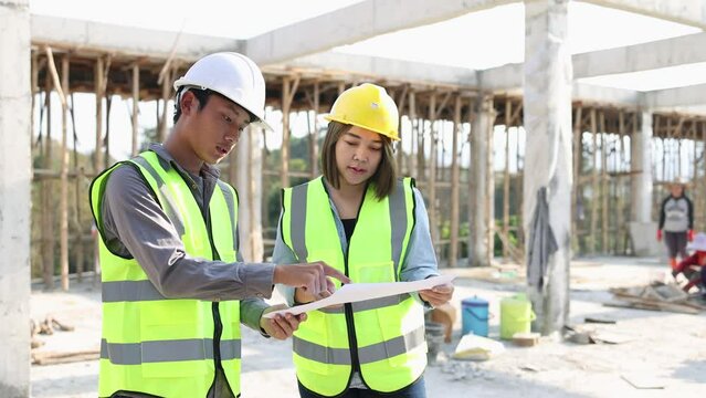 Construction engineers discussing project at construction site, Building construction collaboration concept, Video 4k slow motion.