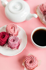 Close up view of delicious pink cupcakes with cup of coffee  on table