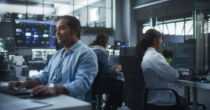Creative Team of Indian Specialists Having a Conversation at a Workplace Next to Computer. Two Male Software Engineers Discussing a Software Code for Their Digital Blockchain Development Project