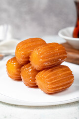 Tulumba dessert. Ramadan sweets. Traditional Turkish cuisine delicacies. Tulumba dessert with syrup on a gray background. Close up