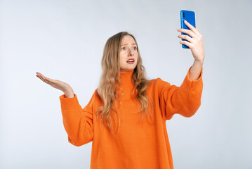Shocked, surprised girl, reacts on something frustrating on mobile phone, complaining on smartphone...