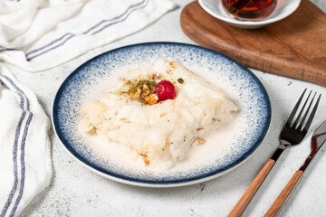 Gullac dessert with walnuts. Ramadan sweets. Traditional Turkish cuisine delicacies. Gullac dessert with cherry, pistachio and walnuts on gray background