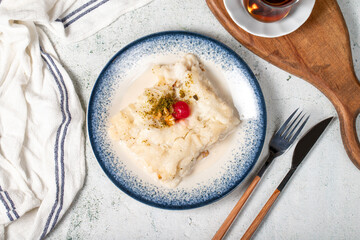 Gullac dessert with walnuts. Ramadan sweets. Traditional Turkish cuisine delicacies. Gullac dessert with cherry, pistachio and walnuts on gray background. Top view