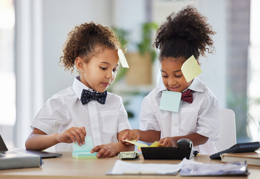 Children, together and playing office with sticky note at desk with happiness, brainstorming and teamwork. Kids, girl and group with paper, planning and play as business people for bond with games
