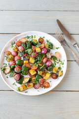 Marinated vegetable salad with roasted red radish and zucchini. Served warm with chopped parsley on...