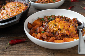 Bean stew with ground beef and gratinated cheddar cheese topping and roasted sweet potatoes
