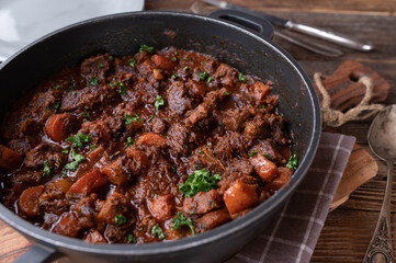 Braised pork with carrots and brown sauce in a pot